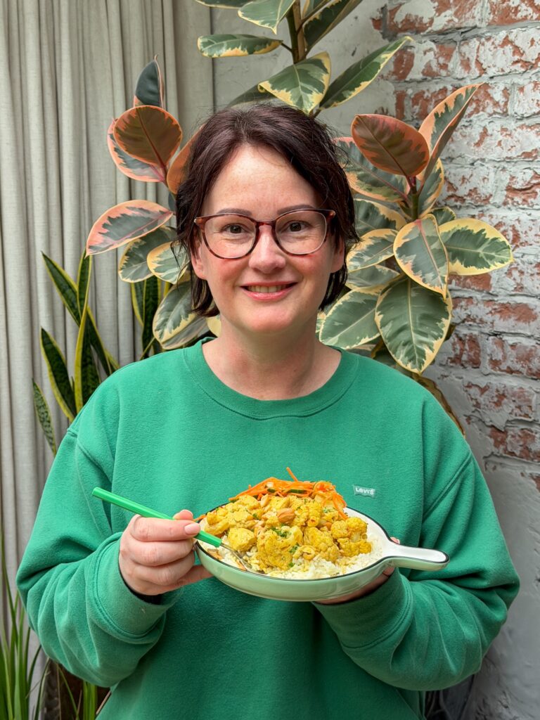 Marie Louise met een bord bloemkoolcurry met kip en rijst