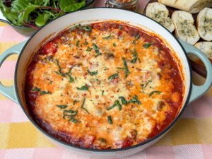 Pittige vegetarische gnocchi ovenschotel in een pan met gesmolten kaas en tomatensaus