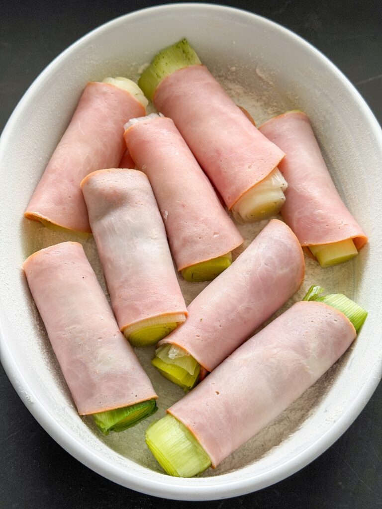 Prei omwikkeld in ham in ovenschaal verdelen