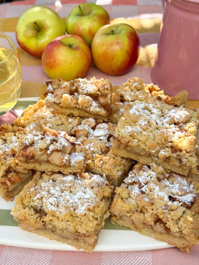 appel kruimel plaattaart in stukken gesneden op schaal met poedersuiker