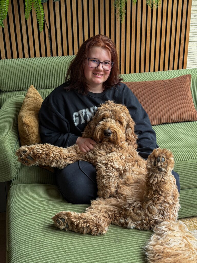 Beaudine knuffelt Teun op de bank in de woonkamer