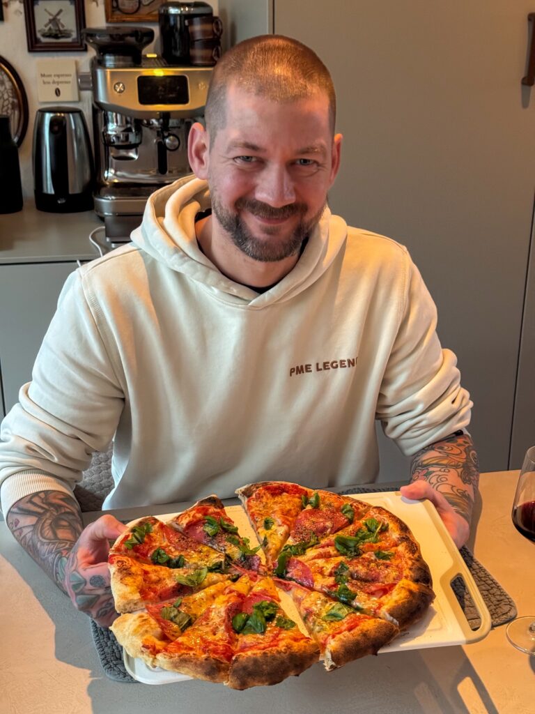 Jan Willem met zelfgemaakte pizza aan tafel in de keuken
