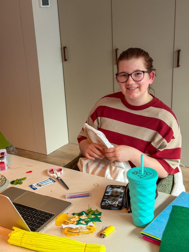 Beaudine knutselt aan tafel met vilt en maakt zelf haar shirt
