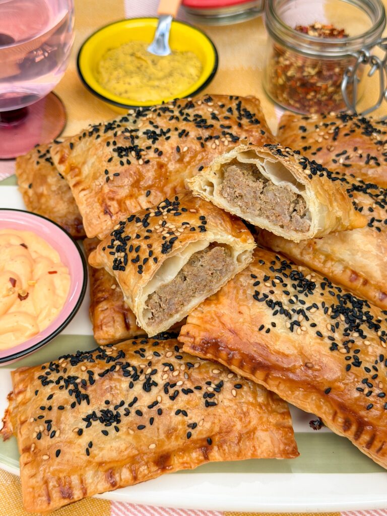 Doorgesneden saucijzenbroodje met kruidige gehaktvulling