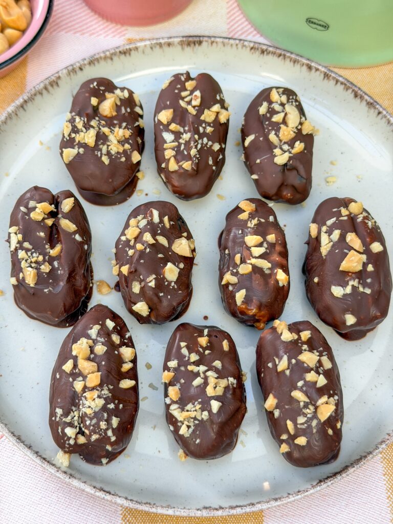 Zelfgemaakte snicker dadels met chocolade en fijngehakte pinda's