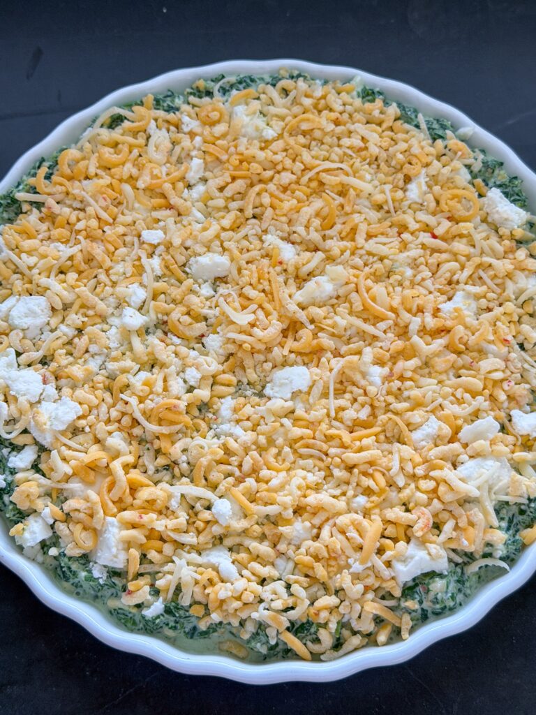 spinaziedip in ovenschaal met feta en texmex kaas klaar om de oven in te gaan