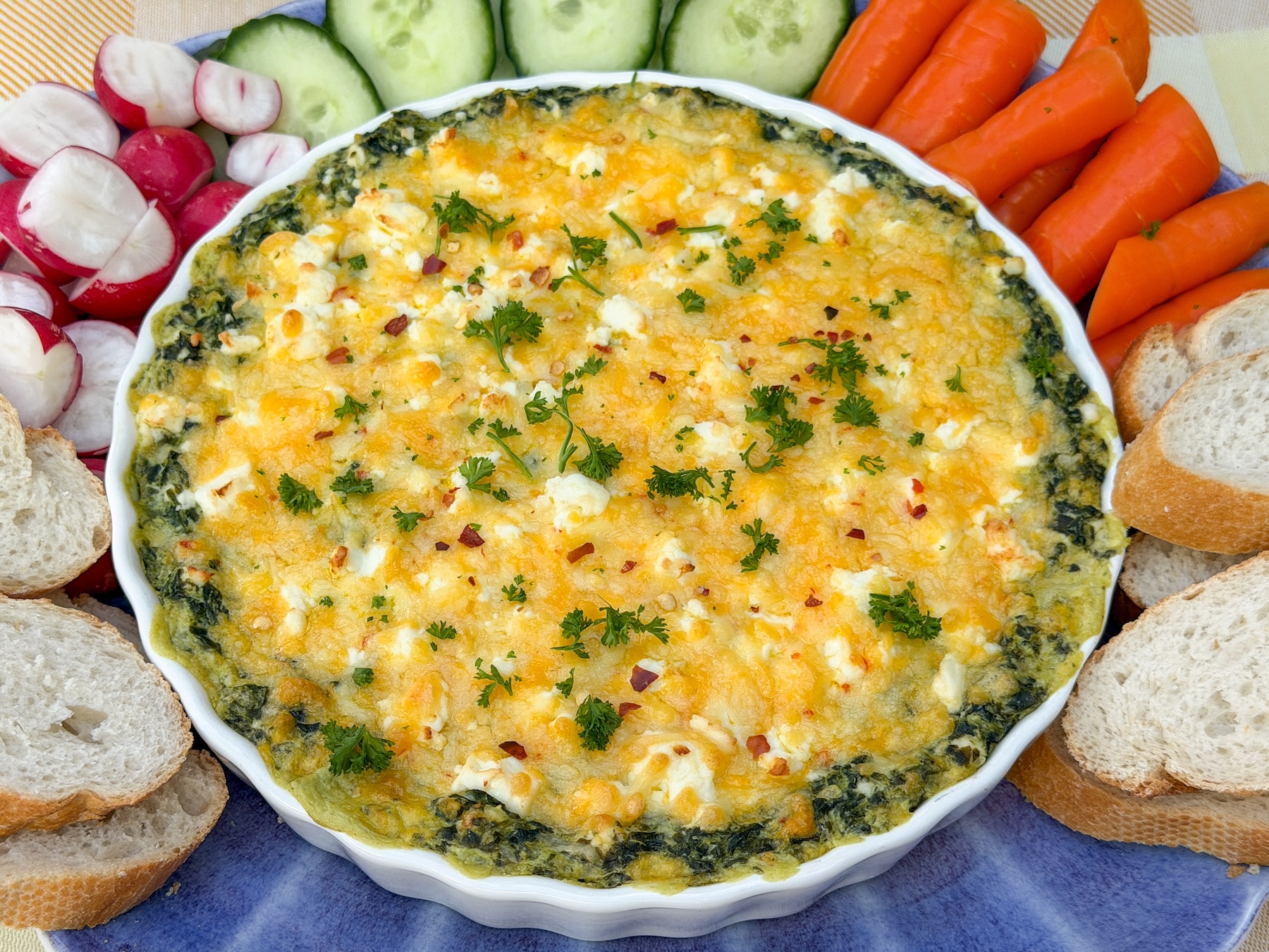 spinaziedip uit de oven met feta en texmex kaas geserveerd met stokbrood en rauwkost