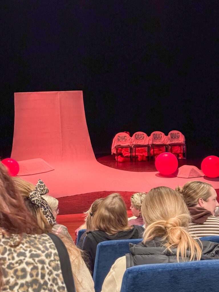 Bezoekers zitten in een theaterzaal voor een voorstelling