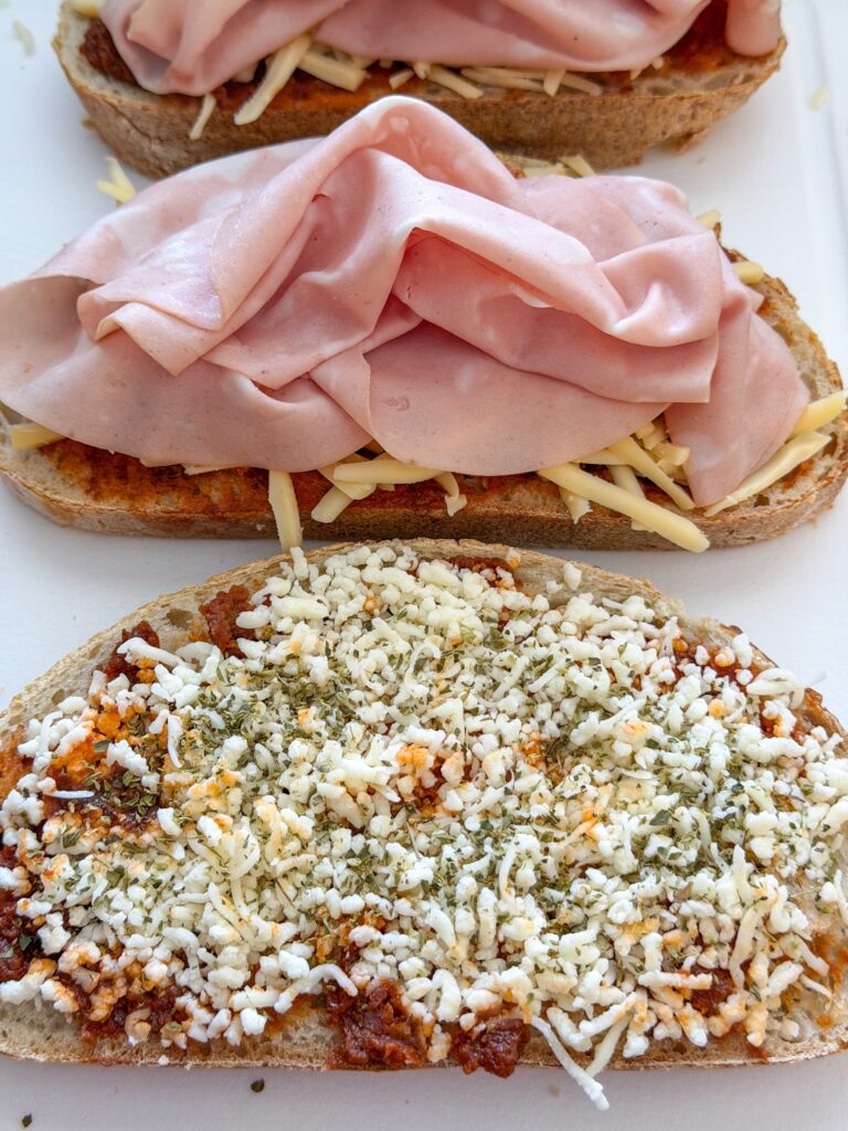 Mozzarella en gedroogde oregano over brood verdelen