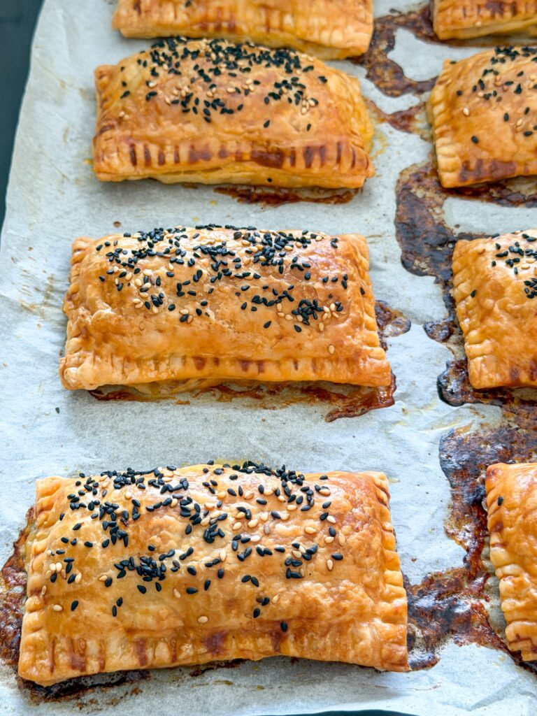 versgebakken saucijzenbroodjes van bladerdeeg op bakplaat