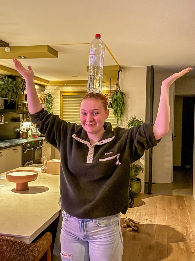 amaranthe balanceert een spa rood fles op haar hoofd