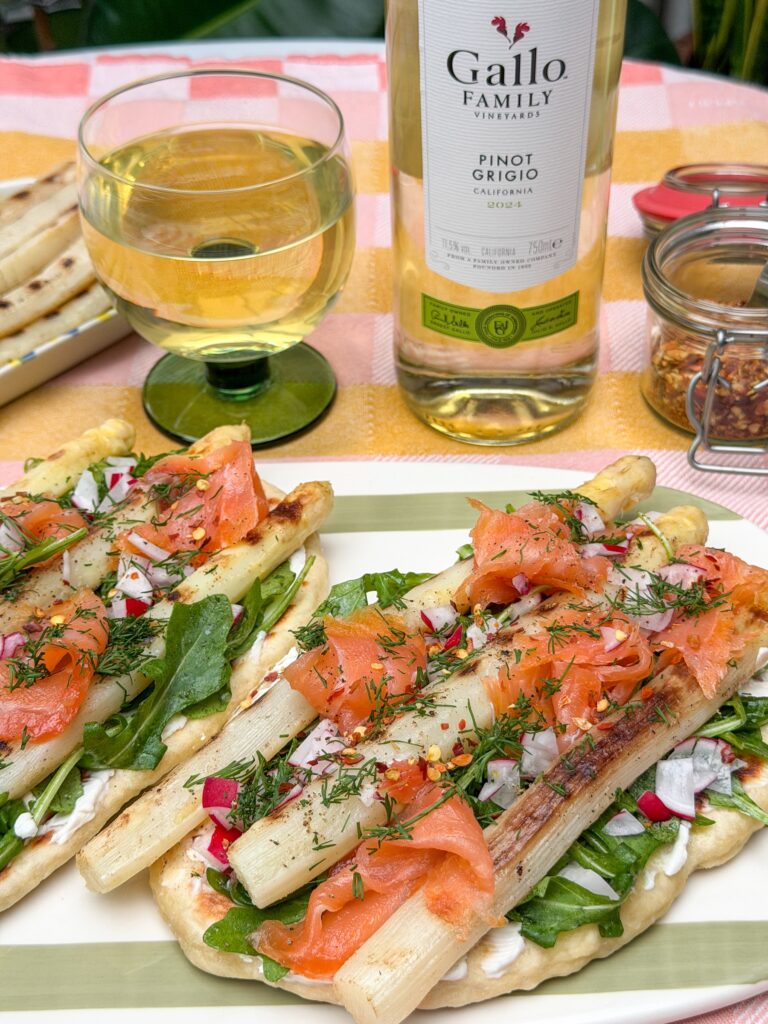 Flatbread met witte asperges en gerookte zalm geserveerd met witte wijn