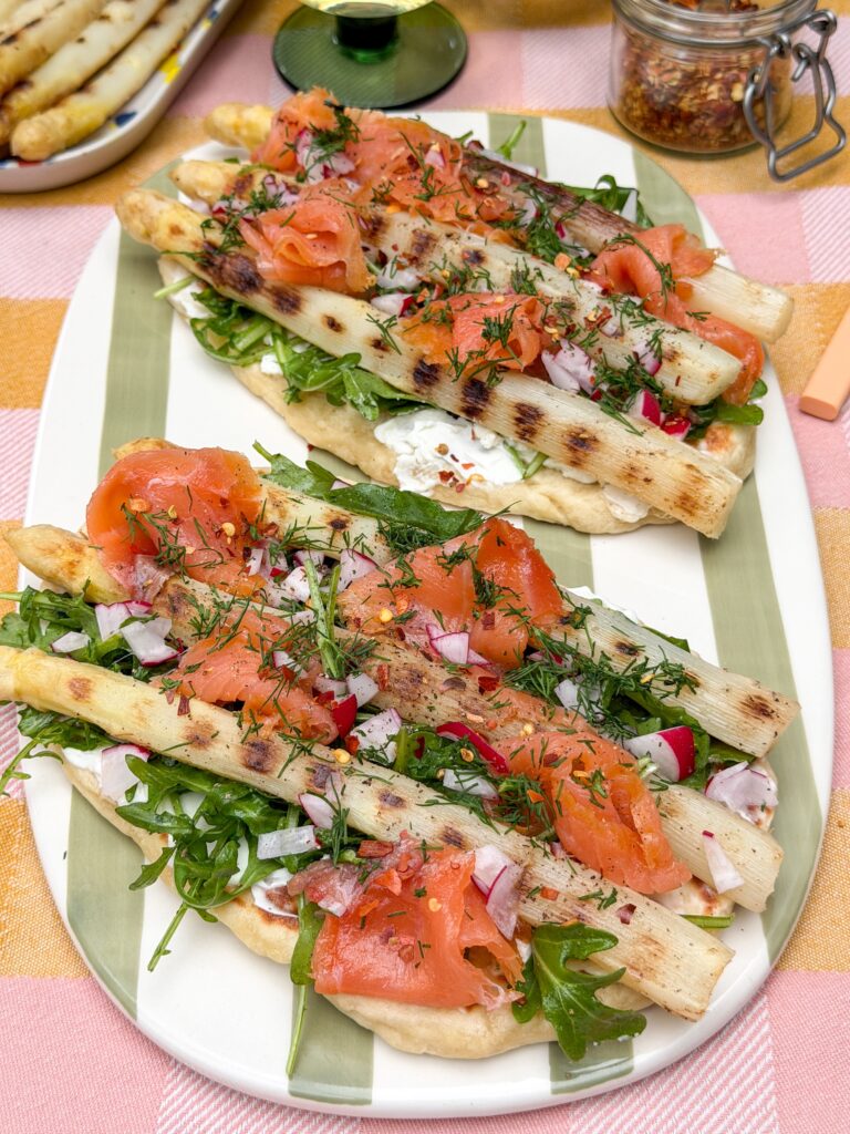 platbrood met zuivelspread, asperges en zalm geserveerd op gestreept bord