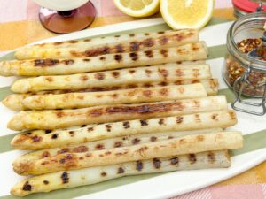 gegrilde witte asperges op schaal geserveerd met citroen en chilivlokken