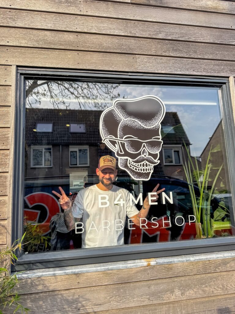 jan willem achter het raam met zijn nieuwe logo