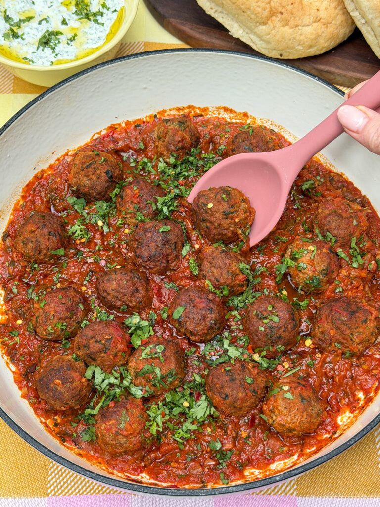marokkaanse gehaktballetjes gestoofd in kruidige tomatensaus in pan met lepel