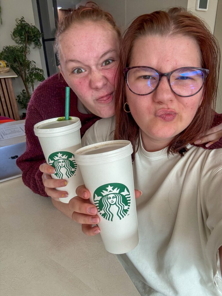 beaudine en amaranthe houden starbucks bekers vast met drankje erin