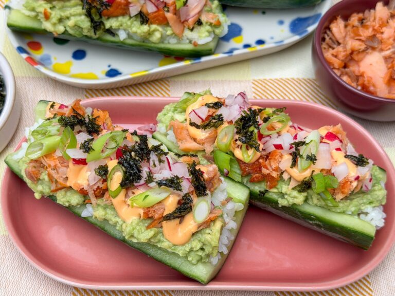 sushi komkommer bootjes met zalm, avocado en sriracha mayonaise op een bord