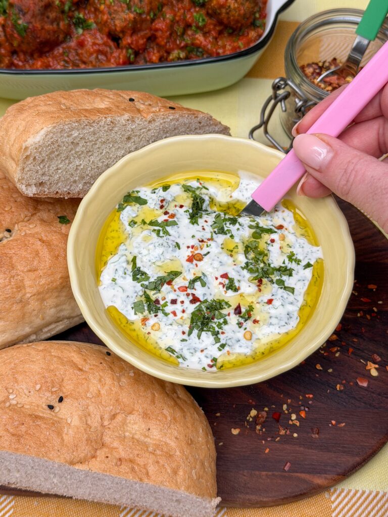 Frisse yoghurt saus met verse munt geserveerd met olijfolie en chilivlokken