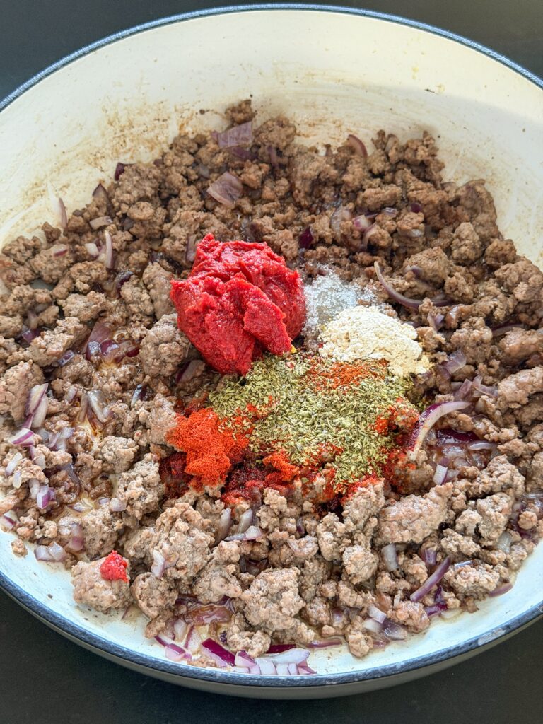 gehakt met ui, tomatenpuree en kruiden aanbakken voor pasta