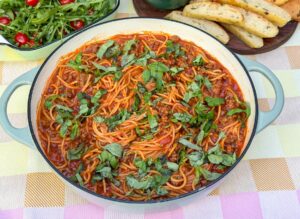 eenpanspasta met gehakt en tomatensaus in een pan met basilicum