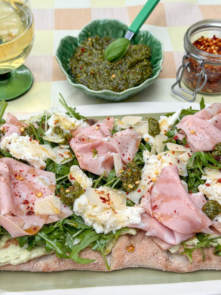 Close up van pinsa met mortadella en pistache pesto