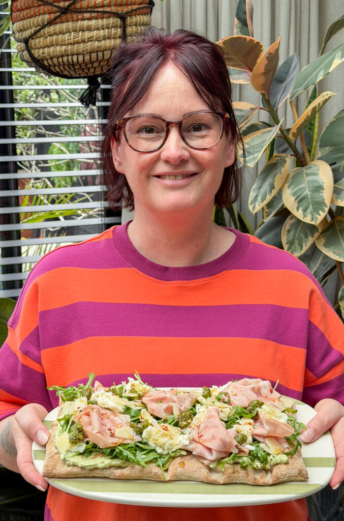 Marie Louise serveert pinsa met mortadella en pesto-roomkaas met mozzarella