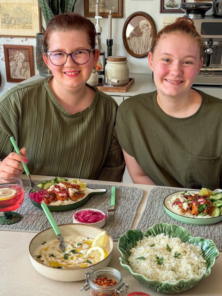 tahini yoghurt dressing geserveerd bij gegrilde kip en rijst aan tafel bij familie over de kook