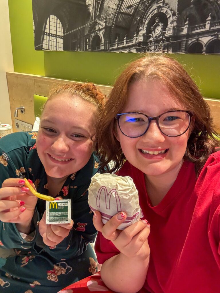 Beaudine en Amaranthe selfie met McDonald's eten