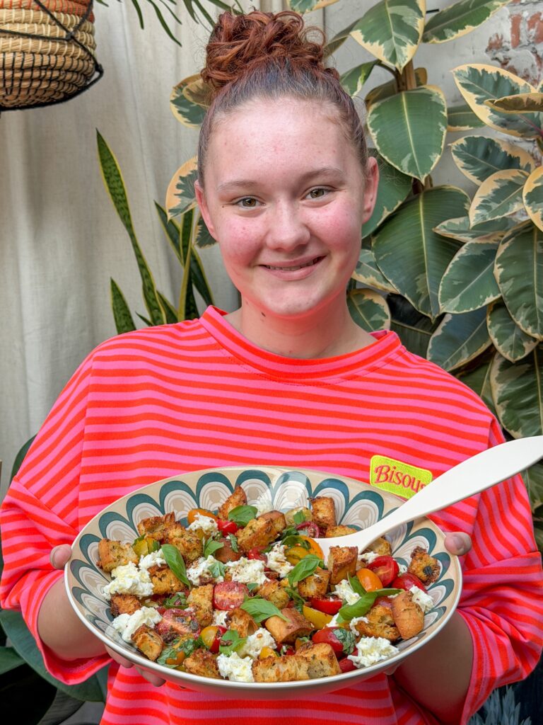 Amaranthe van Familie over de Kook met een grote schaal zomerse salade