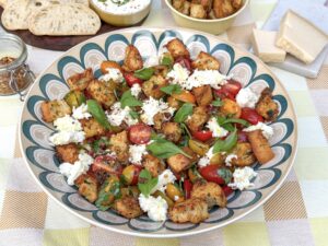Bruschetta salade met mozzarella, gekleurde snoeptomaatjes, basilicum en knoflookcroutons