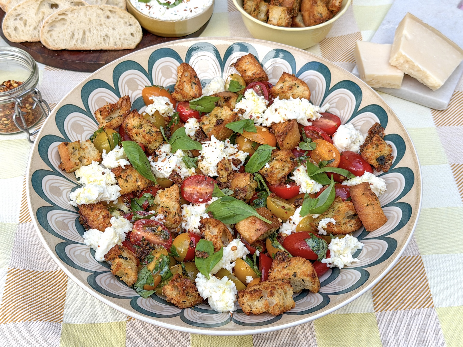 Bruschetta salade met mozzarella, gekleurde snoeptomaatjes, basilicum en knoflookcroutons
