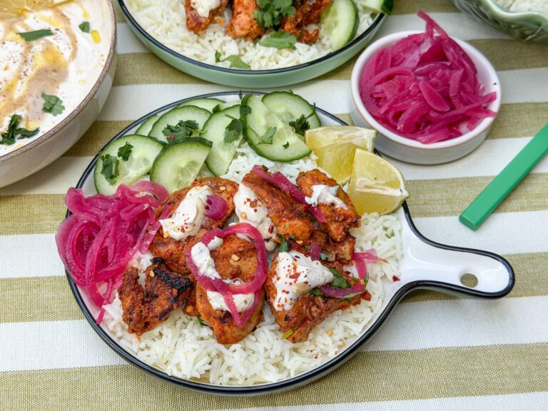 harissa kip met rijst, tahin yoghurt dressing, ingelegde rode ui en komkommer