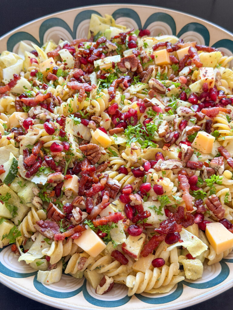 close up van maaltijdsalade met appel, spekjes, blokjes kaas en granaatappelpitjes