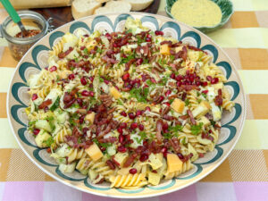 pastasalade met witlof, appel, kaas, spekjes en granaatappelpitjes in schaal