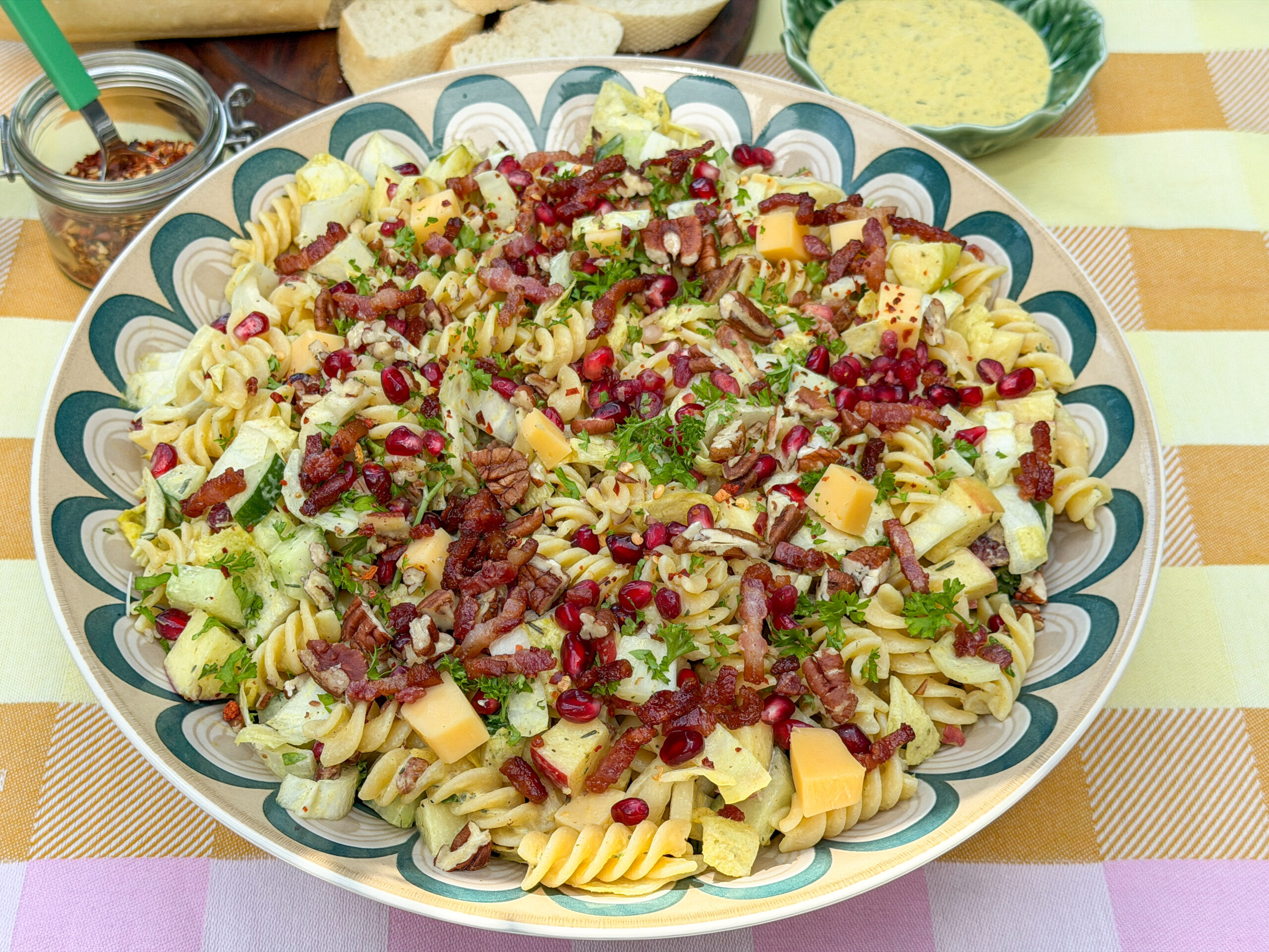 pastasalade met witlof, appel, kaas, spekjes en granaatappelpitjes in schaal