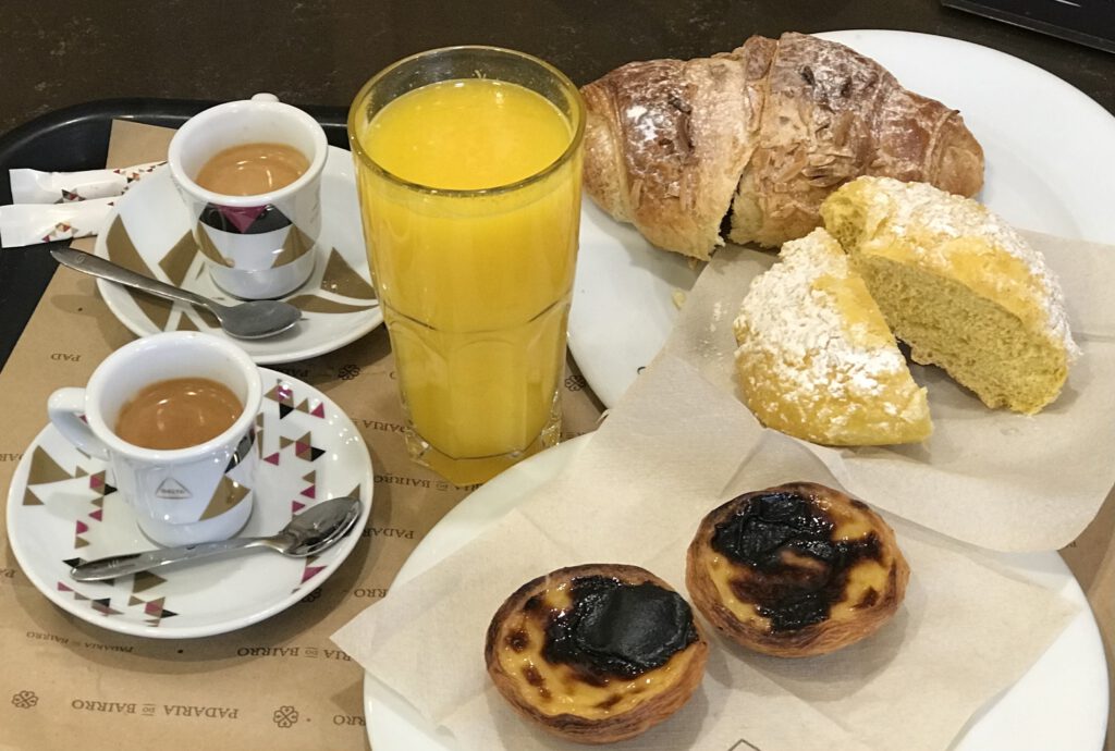 Het Portugese ontbijt, koffie, jus d'orange, een zoet broodje en de bekende Pastel de Nata
