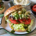 burgers met gebakken uien en geserveerd met een kruidenolie en tomaat