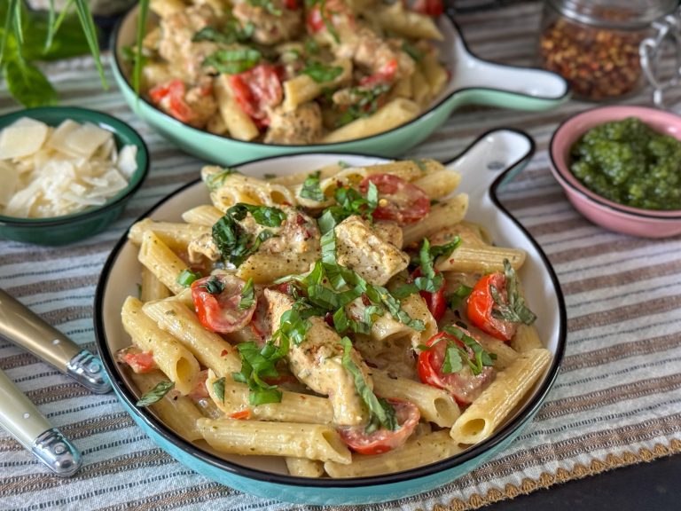 Pasta pesto met kip pasta pesto met kip geserveerd op een rond bord met verse basilicum