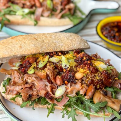 broodje warme beenham met pindasaus met crispy chili olie, seroendeng, rucola en fijngesneden bosui