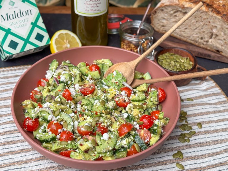 Salade met avocado een schaal met een gezonde salade met avocado, feta, tomaatjes en kruidige Italiaanse dressing.