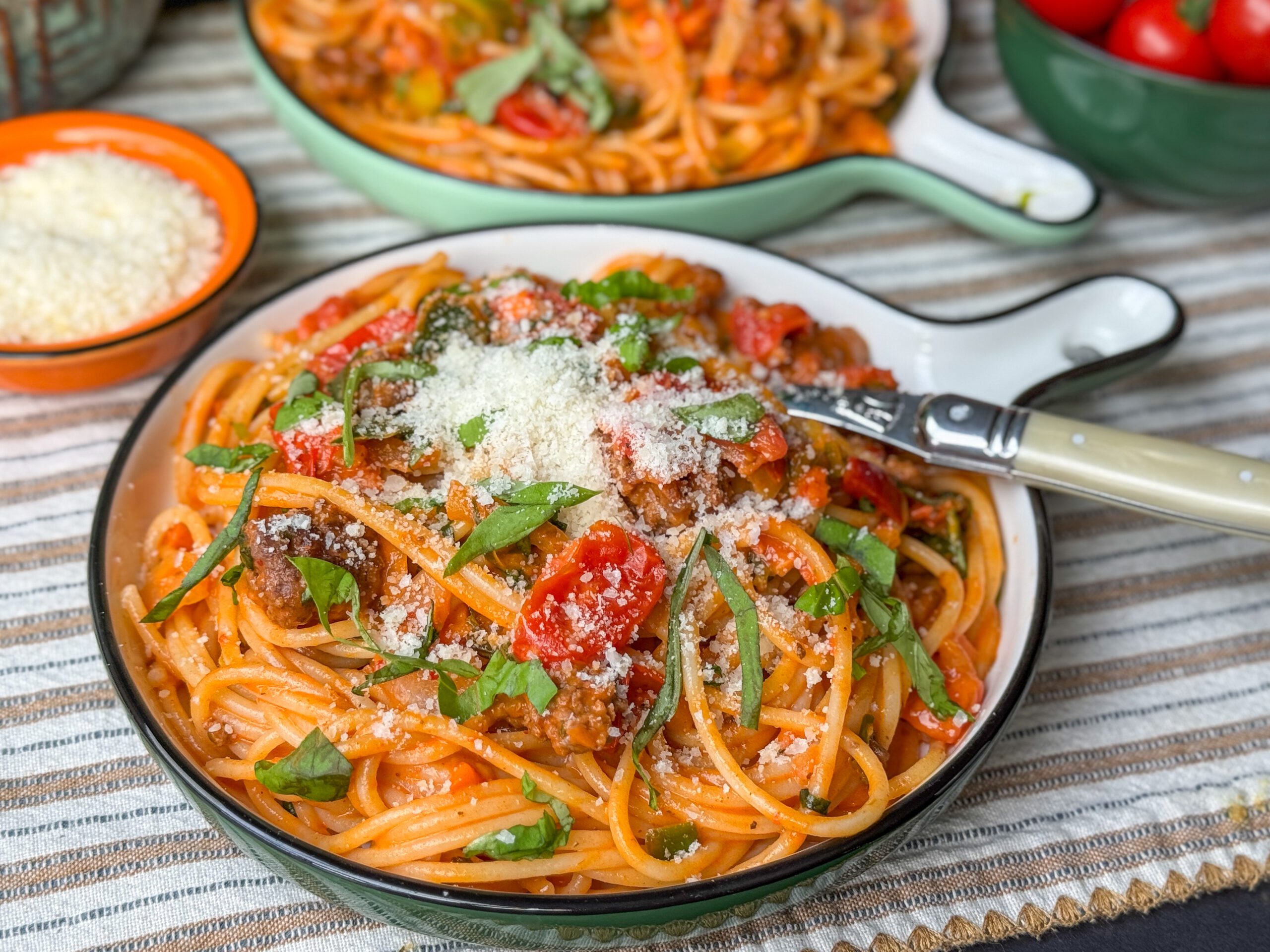 een bord vol heerlijke romige pasta met nduja en verse basilicum. Geserveerd met geraspte kaas