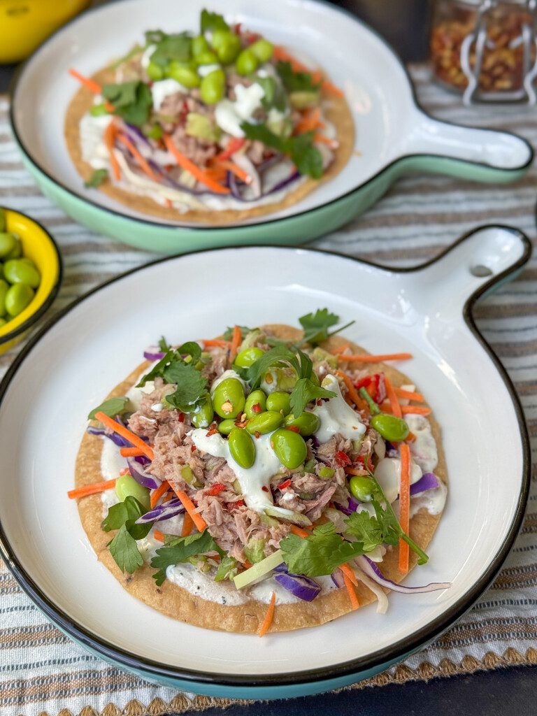 Knapperige tostada’s met tonijn, koolmix en avocado, geserveerd op een bord met frisse yoghurt dressing. 