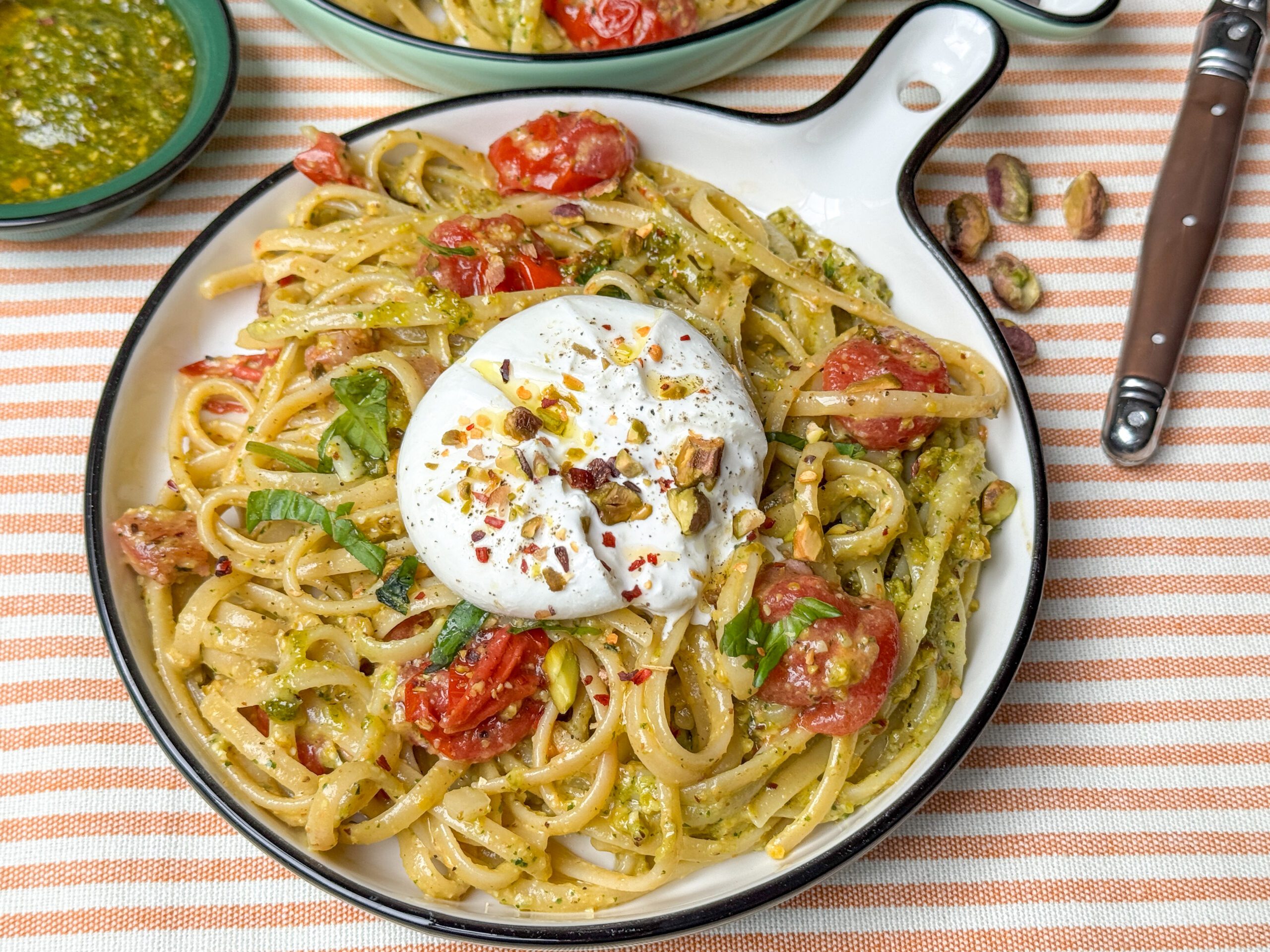 Makkelijke pasta met pistache pesto, burrata, pancetta en geroosterde tomaatjes