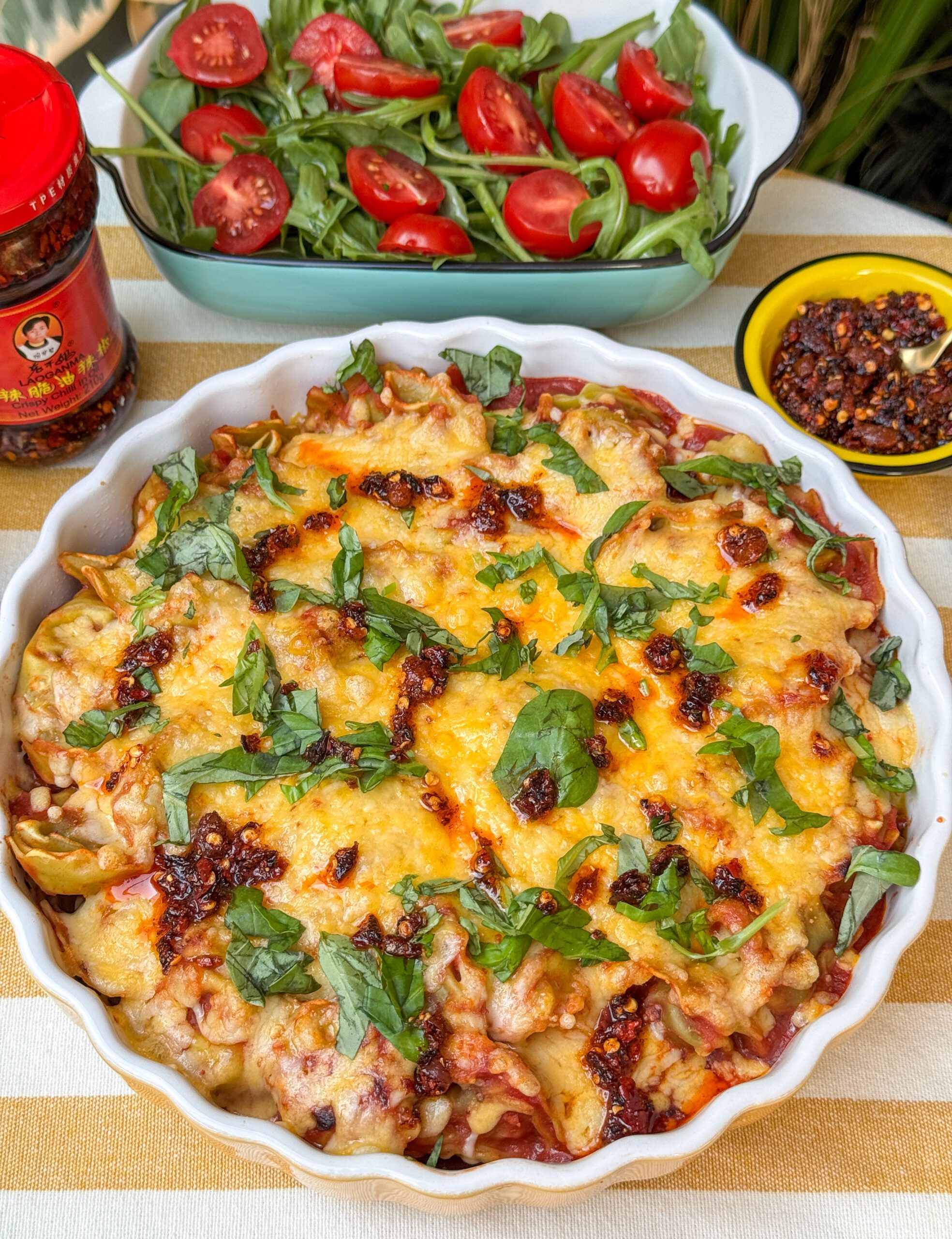 Tortellini ovenschotel met tomatensaus en crispy chili olie, geserveerd met verse basilicum