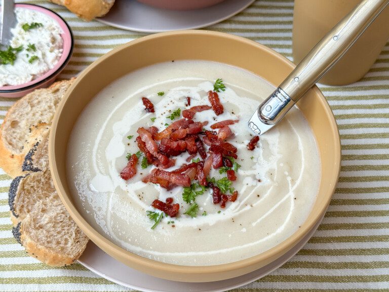Bloemkoolsoep - romig basisrecept bloemkoolsoep met spekjes recept - romige soep in kom geserveerd met peterselie en krokant spek