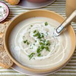 bloemkoolsoep recept - romige soep geserveerd in lichtgele kom met verse peterselie