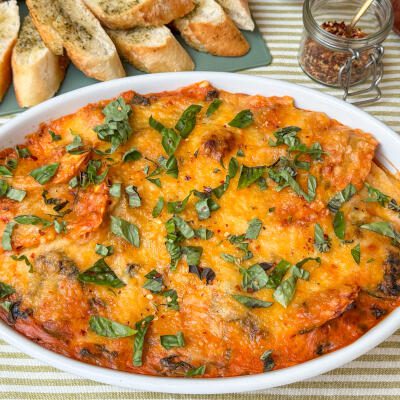 Romige ravioli ovenschotel met spinazie ravioli ovenschotel met spinazie in romige tomatensaus, in witte ovenschaal met gesmolten kaas