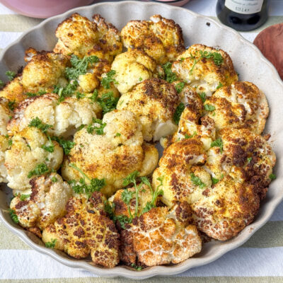 Geroosterde bloemkool uit de oven geroosterde bloemkool uit de oven recept geserveerd in ovenschaal met peterselie