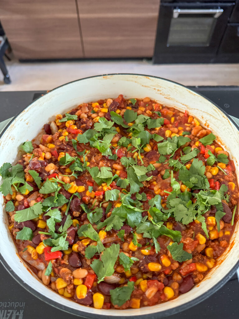 vegetarische chili con carne na pruttelen in pan met koriander geserveerd